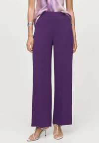 Pantalons larges violets en tissu lisse avec une taille plate, présentant un ourlet net et sans matériel visible.