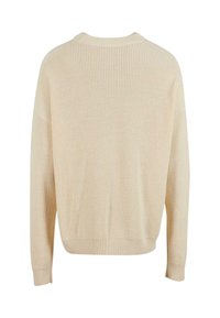 Pull en tricot beige à coupe ample, texture côtelée, encolure large et manches longues. Aucune motif ou détail matériel visible.