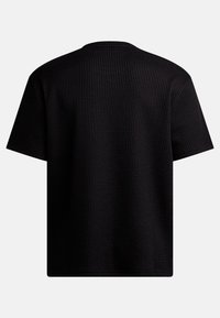 Svart kortermet t-skjorte i teksturert, ribbet stoff, med rund halsdesign og ren, rett skjæring i kanten og ermene.