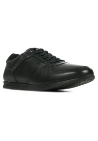 Scarpe atletiche in pelle nera con design a lacci, finitura liscia e cuciture sottili. Presentano una suola in gomma texturizzata per una presa migliore.