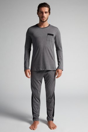 Graues Langarmshirt mit schwarzer Tasche und passender Hose mit schwarzen Seitenstreifen. Weicher Stoff mit lässiger Passform.