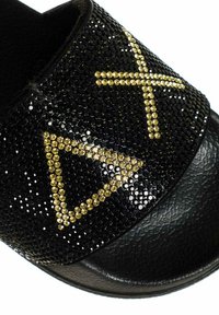 Ciabatta nera con upper testurizzato decorato con motivi geometrici in strass oro e nero. Suola nera opaca con minimo battistrada.
