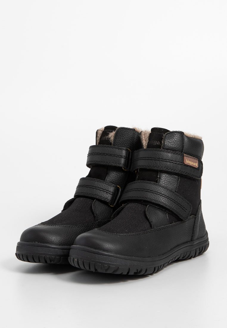 Schwarze Knöchelstiefel mit zwei verstellbaren Klettverschlüssen, aus Leder und Textil gefertigt, mit einem Futter aus Kunstfell und strukturierten Gummisohlen.