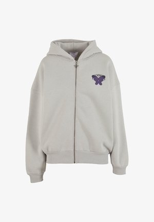 Világosszürke kapucnis pulóver elülső cipzárral, kenguruzsebbel és lila pillangó grafikával a bal mellrészen. Puha anyag és bordázott mandzsetták.