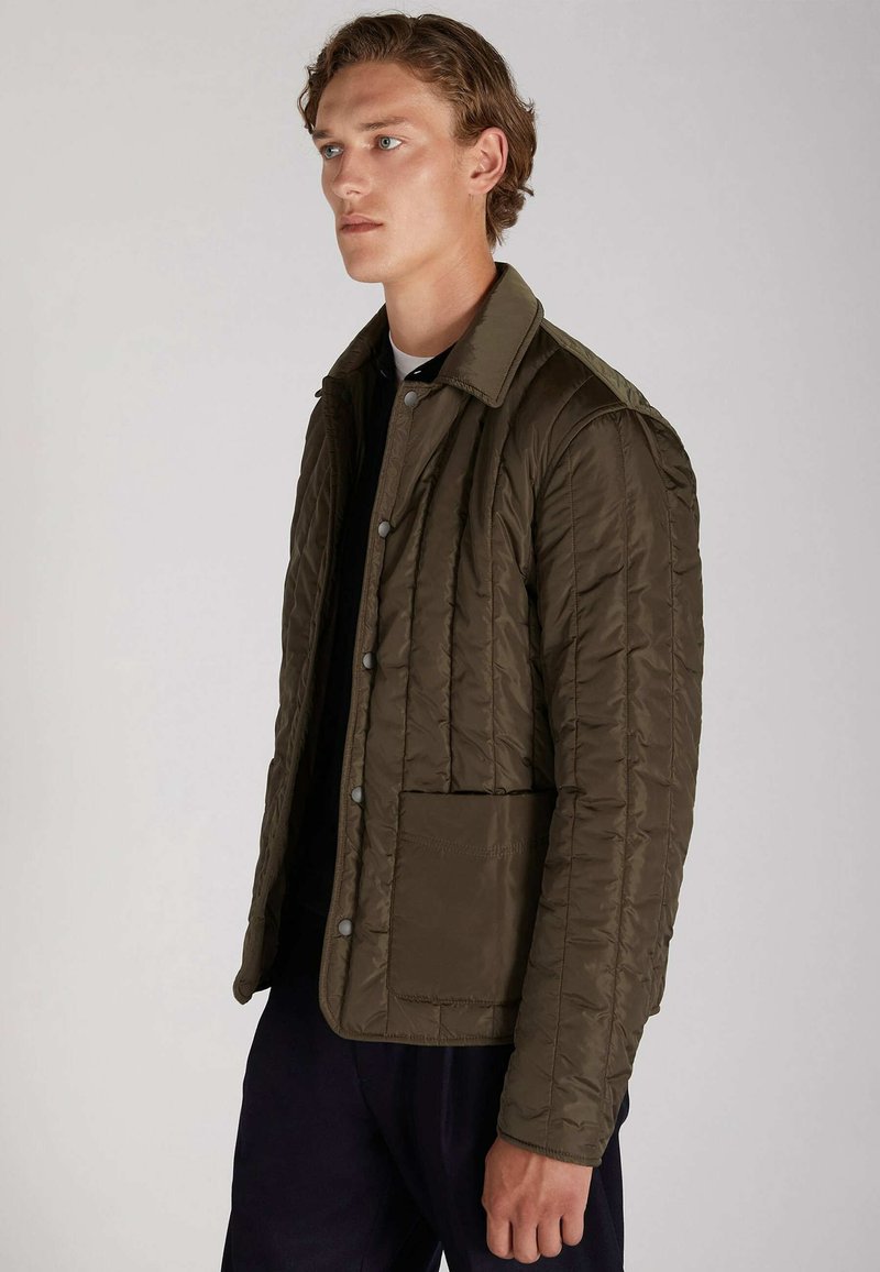 Veste matelassée vert olive avec col, poche avant et fermeture à boutons-pression ; présente une texture lisse et brillante ainsi qu'un design structuré.