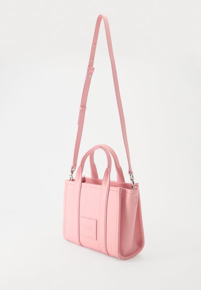 Petit sac à main rectangulaire en cuir rose avec deux poignées courtes et une longue bandoulière réglable, présenté sur un fond uni.