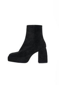 Botas de tobillo de ante negro con un tacón rectangular y chunky, y una suela de plataforma. Textura suave y diseño simple y elegante.