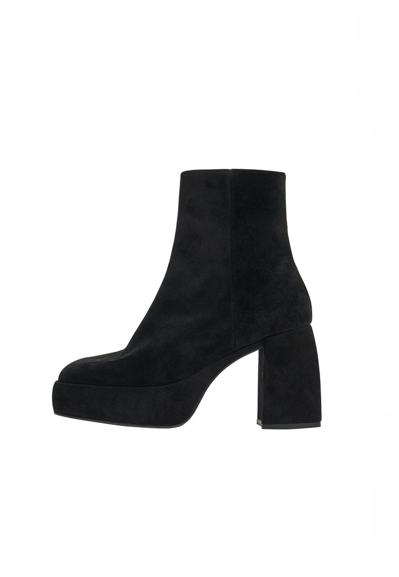Botas de tobillo de ante negro con un tacón rectangular y chunky, y una suela de plataforma. Textura suave y diseño simple y elegante.