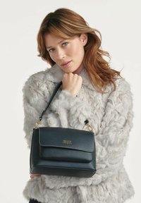 Czarna skórzana torebka o strukturalnym designie, ze złotymi akcentami i przednią kieszenią na klapę. Torebka ma odpinany pasek i teksturowaną powierzchnię.