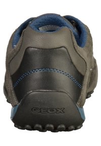 Zadní pohled na šedé semišové a černé kožené sneakers, s modrými akcenty, texturovanou podrážkou a značkovým označením GEox na patě.