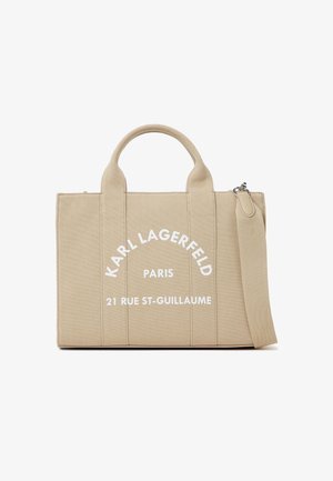 Bézs színű, téglalap alakú kézitáska dupla fogantyúval és levehető pánttal, elöl fehér "Karl Lagerfeld Paris 21 Rue St-Guillaume" felirattal.
