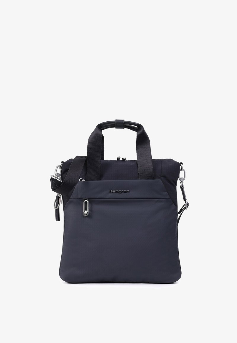 Sac cabas noir Hedgren avec double poignée, une bandoulière amovible et une poche avant zippée sur fond blanc.