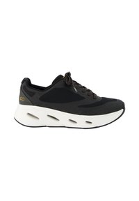 Chaussure de sport noire avec tige en mesh, bout arrondi, semelle intermédiaire épaisse blanche et semelle noire contrastante. Présente des lacets et un détail de logo à l'arrière.