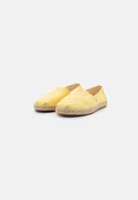 Gele espadrille schoenen met een canvas bovenwerk, ronde neus en een jute touwzool. Eenvoudig ontwerp met gestikte details op het oppervlak.