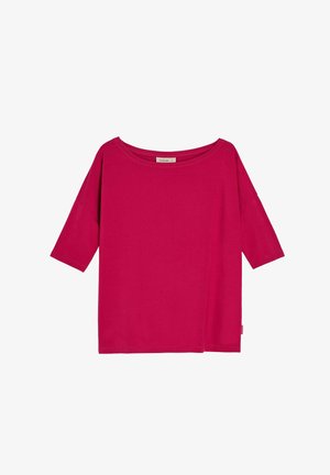 Jasnoróżowa luźna koszulka z rękawami do połowy ramienia i szerokim, okrągłym dekoltem na białym tle.