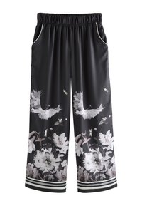 Fekete, lenge nadrág virágmintával, amely fehér madarakat és szürke virágokat ábrázol. Oldalzsebekkel és a szegélyen csíkos díszítéssel rendelkezik.