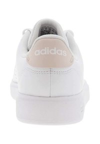 Zapatillas Adidas blancas con una parte superior de cuero suave, acento rosa en el talón y una suela de goma texturizada. Logo mostrado en la parte trasera.