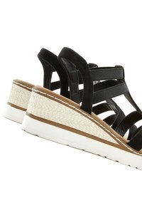 Schwarze Riemchen-Wedgesandalen verfügen über eine strukturierte weiße Plateau-Sohle, eine braune Wildleder-Innensohle und stabile schwarze elastische Riemen für zusätzlichen Halt.