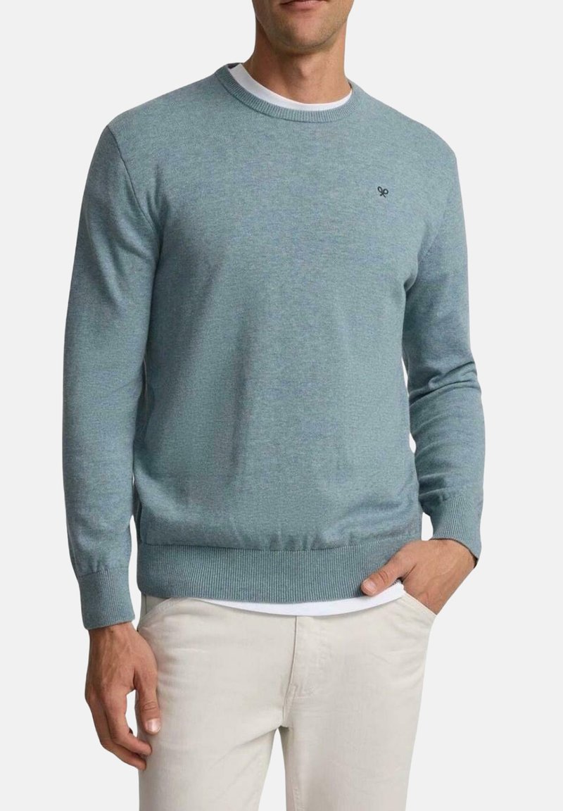 Suéter de punto azul claro con cuello redondo, mangas largas, puños y dobladillo acanalados, con un pequeño logo en el pecho.