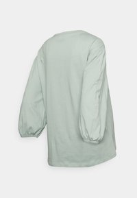 Camisola de manga longa verde menta feita de algodão macio. Apresenta mangas bufantes e um corte descontraído, com um decote redondo e sem fechos visíveis.