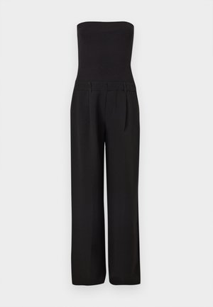 Mono negro sin tirantes con cuerpo ajustado acanalado y pantalones anchos de corte sastre.