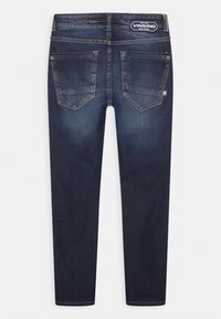 Mörkblå denimjeans med slim fit, featuring två bakfickor och ljus blekning på låren. Logotypetikett på midjan.