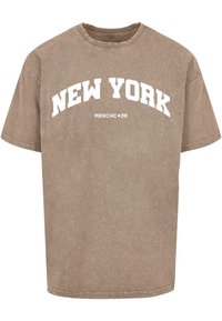Rudas didelis marškinėliai, pagaminti iš medvilnės, su balta išgaubta „NEW YORK“ užrašu, trumpomis rankovėmis ir standartiniu apvaliu iškirpimu.