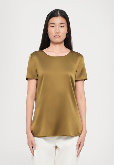 Blusa verde oliva de manga corta con escote redondo. Confeccionada en un tejido suave, presenta un corte relajado y un caído suave. El dobladillo llega a la altura de la cadera.