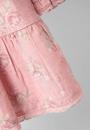 Roosa lilleline kleit, mis on valmistatud kergest kangast, omades tekstureeritud pinda, volangkäiseid ja peent pitsi äärist hemil.