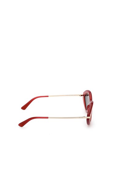 Červené sluneční brýle s odvážným tvarem kočičího oka, s lesklým plastovým rámem, tenkými zlatými kovovými nohami a tmavými čočkami.