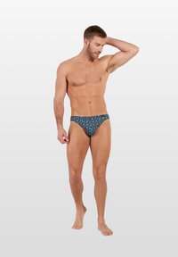 Herren-Schwimmslips mit einem schwarz-blau-türkisfarbenen Blütenmuster, die eine enge Passform und eine glatte Textur bieten, geeignet für aquatische Aktivitäten.