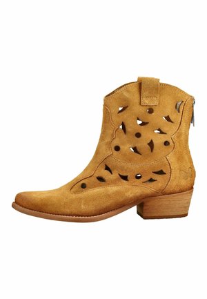 Bottine en daim beige avec motifs floraux découpés, talon bloc en bois et fermeture éclair latérale.