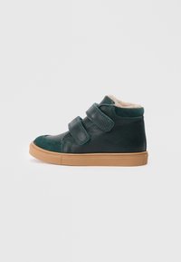 Grüner Leder-Hochschuh mit beigen Klettverschlüssen, weicher Innenausstattung und Sohle aus Gummi. Mit Wildlederakzenten an Zehen und Knöchel.