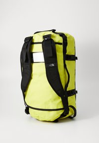 Yellow waterproof backpack with black straps and accents. Features a reflective panel and adjustable buckles for secure carrying.
