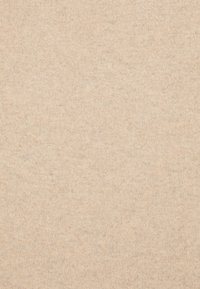 Beige Strickstoff mit einer glatten Textur, der leichte Farbvariationen und ein einheitliches Rippmuster aufweist.