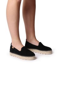 Mustad nahast espadrillid, millel on libisev disain, jute-kattega vaheosas ja nähtavad õmblused ääre ümber.