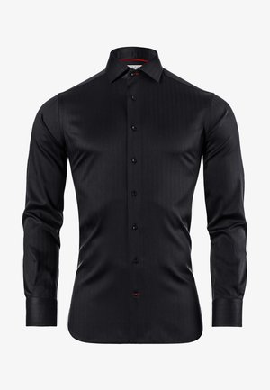 Chemise noire à manches longues, fermeture à boutons sur le devant, fabriquée en tissu lisse avec un subtil motif à rayures verticales. Présente des boutons noirs et un accent rouge.