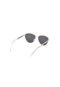 Ochelari de soare în stil cat-eye cu lentile întunecate, ramă metalică de culoare aurie și vârfuri transparente ale bratelor. Design ușor cu o formă unică.
