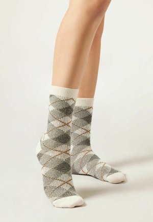 Chaussettes grises à motifs avec des accents blancs et un design en diamant. Fabriquées en tissu texturé avec un bord côtelé.