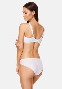 Biały zestaw bielizny o gładkiej fakturze i prostym designie. Biustonosz ma regulowane ramiączka, a majtki mają średni fason.
