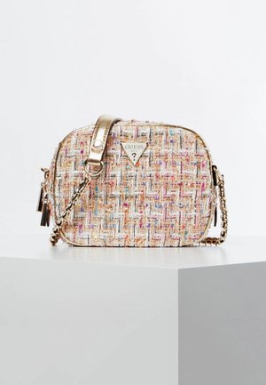 Lille vævet stof crossbody taske med guldkæde rem og Guess-logo foran, placeret på en hvid piedestal mod en ensfarvet baggrund.