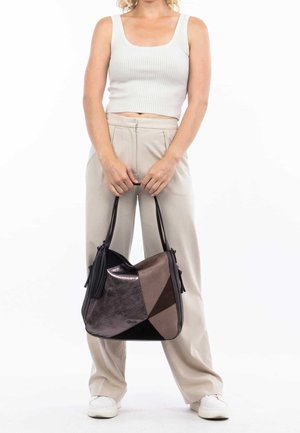 Sac à motifs triangulaires dans des nuances de noir et de marron, fabriqué à partir de matériaux brillants et mats, avec des franges et une large bandoulière.