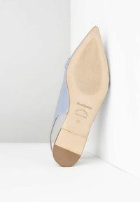 Talons en cuir bleu clair avec un bout pointu et un design élancé. Détail de sangle unique, texture lisse et semelle extérieure marron striée.