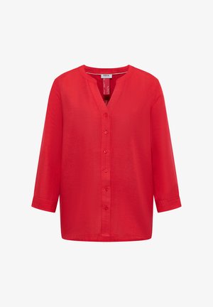 Czerwona lniana bluzka z długim rękawem, z kołnierzykiem typu mandaryński i zapięciem na guziki z przodu, zaprojektowana przez Cecil.
