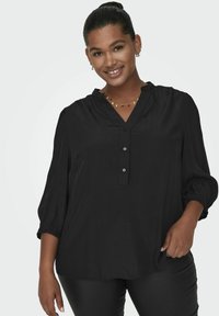Blusa negra de botones con escote en V y mangas de tres cuartos. La tela es ligera con un acabado texturizado y presenta puños elásticos.