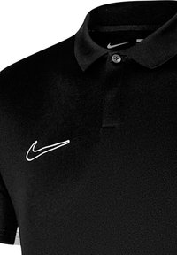 Schwarzes Polohemd aus glattem Stoff, mit klassischem Kragen, einem Knopf und einem weißen Nike-Swoosh-Logo auf der linken Brust.