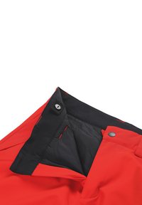 Pantaloni isolati rossi con vita nera, dotati di chiusura con bottone e cuciture a contrasto. Interno foderato in tessuto nero.