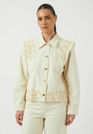 Crème denimjack met bloemenborduursel op de schouders en de zoom, met een kraag en koperen knopen. Glad textuur, comfortabele pasvorm.