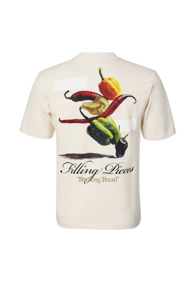Rückseite eines T-Shirts mit bunten Chilischoten-Grafiken und dem Text "Filling Pieces" und "Breaking Bread" auf schlichtem hellem Hintergrund.