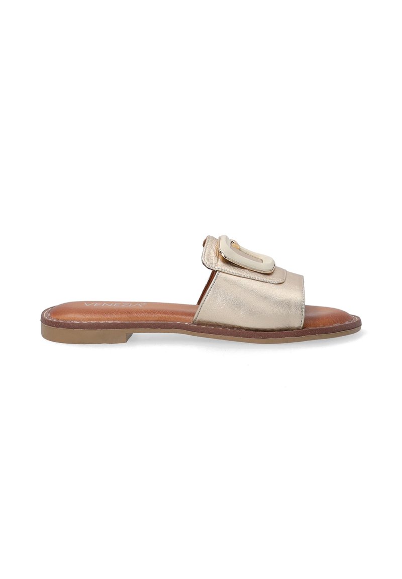 Metallic gold slide sandal with a wide strap and a decorative buckle, featuring a flat sole and brown insole. Smooth texture and modern design.